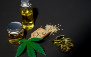 CBD Oil and marijuana leaves on a table.