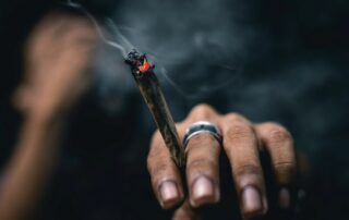 A person holding a lit joint