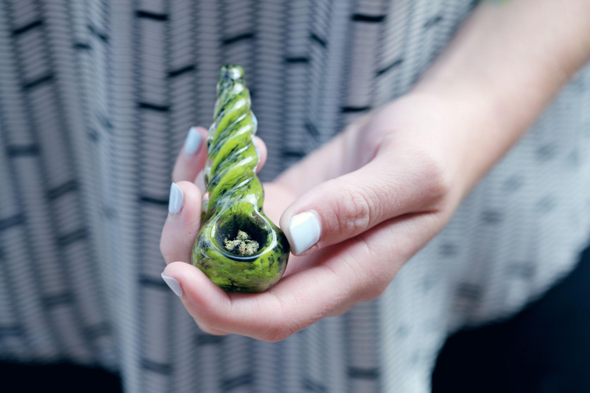 Person holding a pipe with medical marijuana
