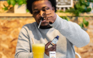 A man adding CBD oil to his drink.