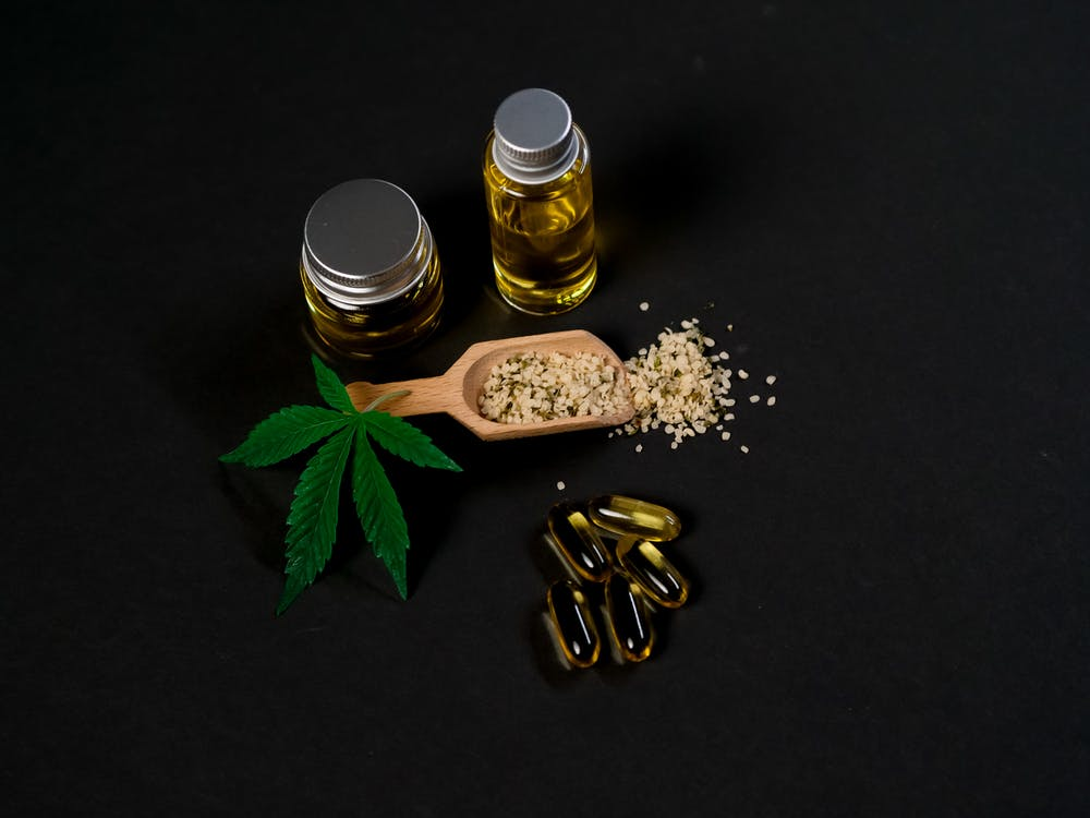Marijuana and CBD capsules on a dark background